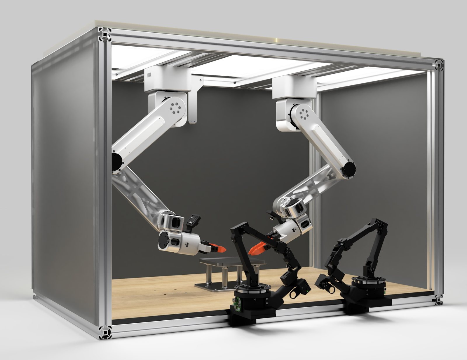 The S2: two white metal arms mounted overhead inside an enclosed aluminium frame with integrated ceiling lighting, working above a clear wooden deck. The two black arms from the current cell stand on the deck for scale.